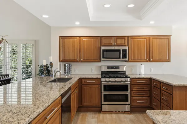 a kitchen with sink a microwave and cabinets