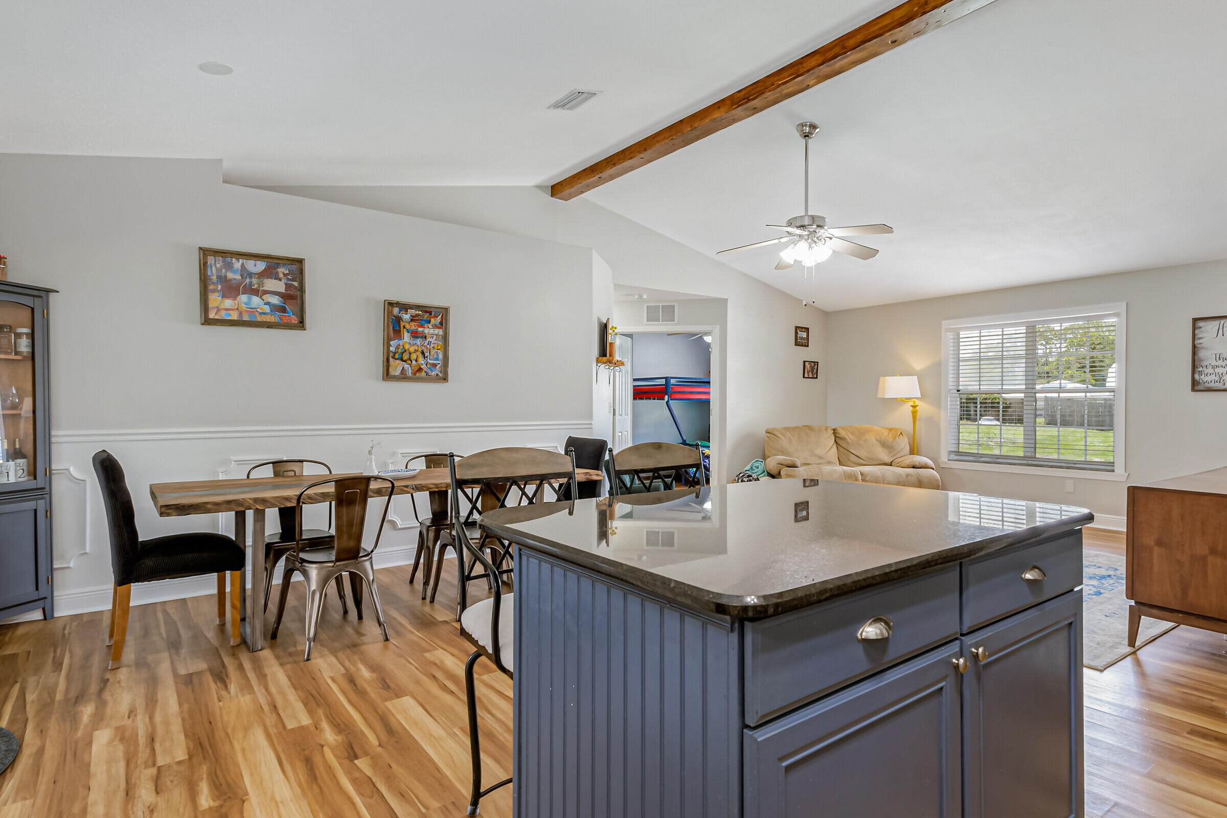 1030 San Rafael Road Southwest Palm Bay, FL 32908 - Photo 15 of 37 a room with a center island a dining table wooden floor and a view of kitchen