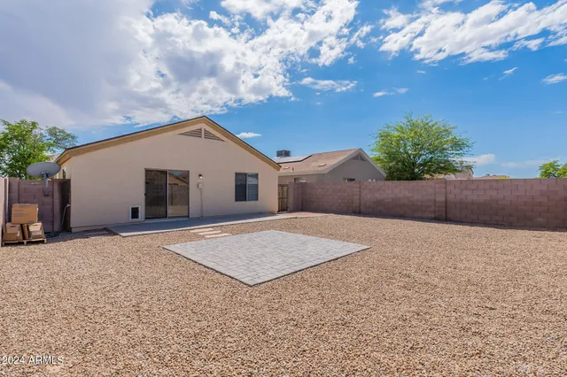 a view of backyard of house and car parked