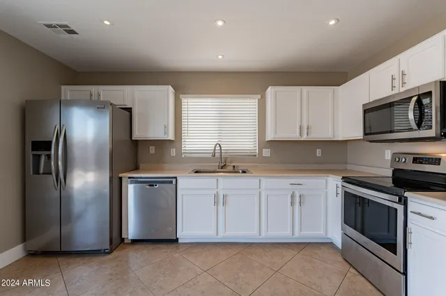 a kitchen with cabinets stainless steel appliances and window