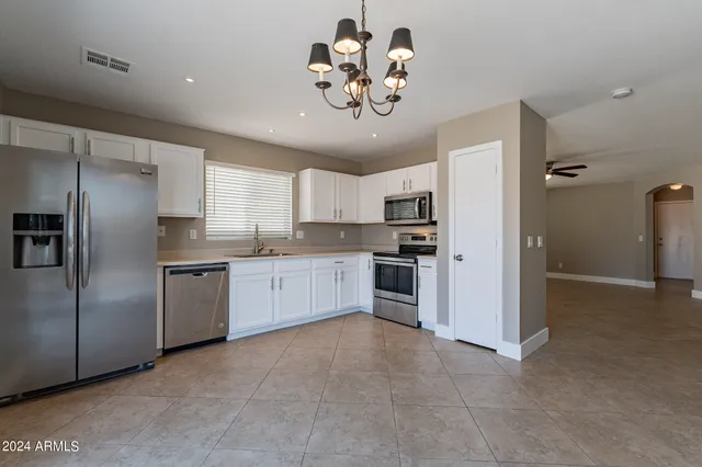 a kitchen with refrigerator cabinets and window