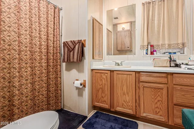 a bathroom with a granite countertop sink toilet and mirror
