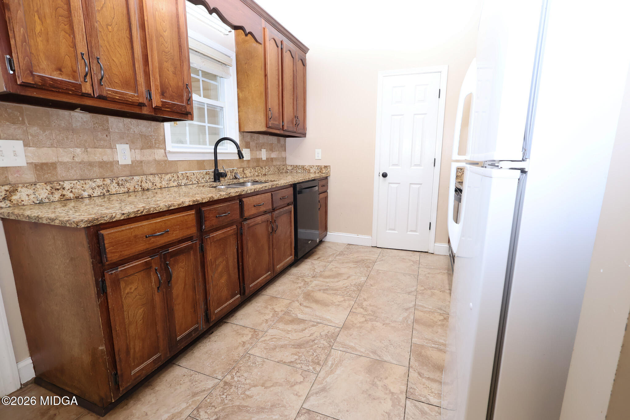 1025 Feagin Mill Road Warner Robins, GA 31088 - Photo 7 of 28 a kitchen with a sink refrigerator and cabinets