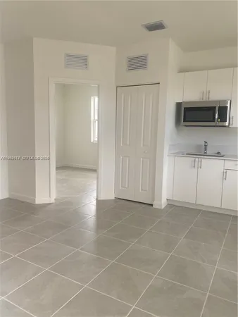 a view of a kitchen with an empty space and a window