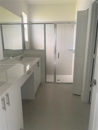 a bathroom with a granite countertop sink a mirror and a bathtub