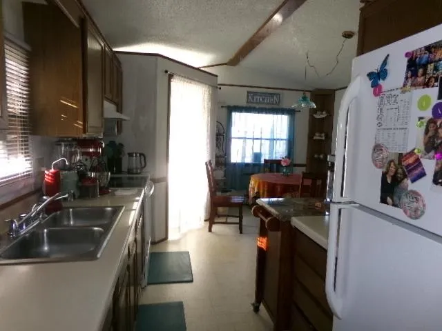 a kitchen that has a sink a stove and a refrigerator