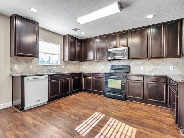 a view of a kitchen with a sink and wooden floor