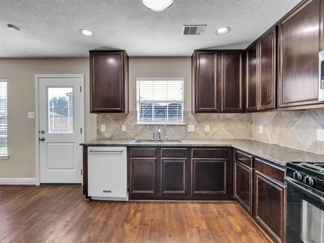 a kitchen with stainless steel appliances granite countertop a stove a sink and a refrigerator