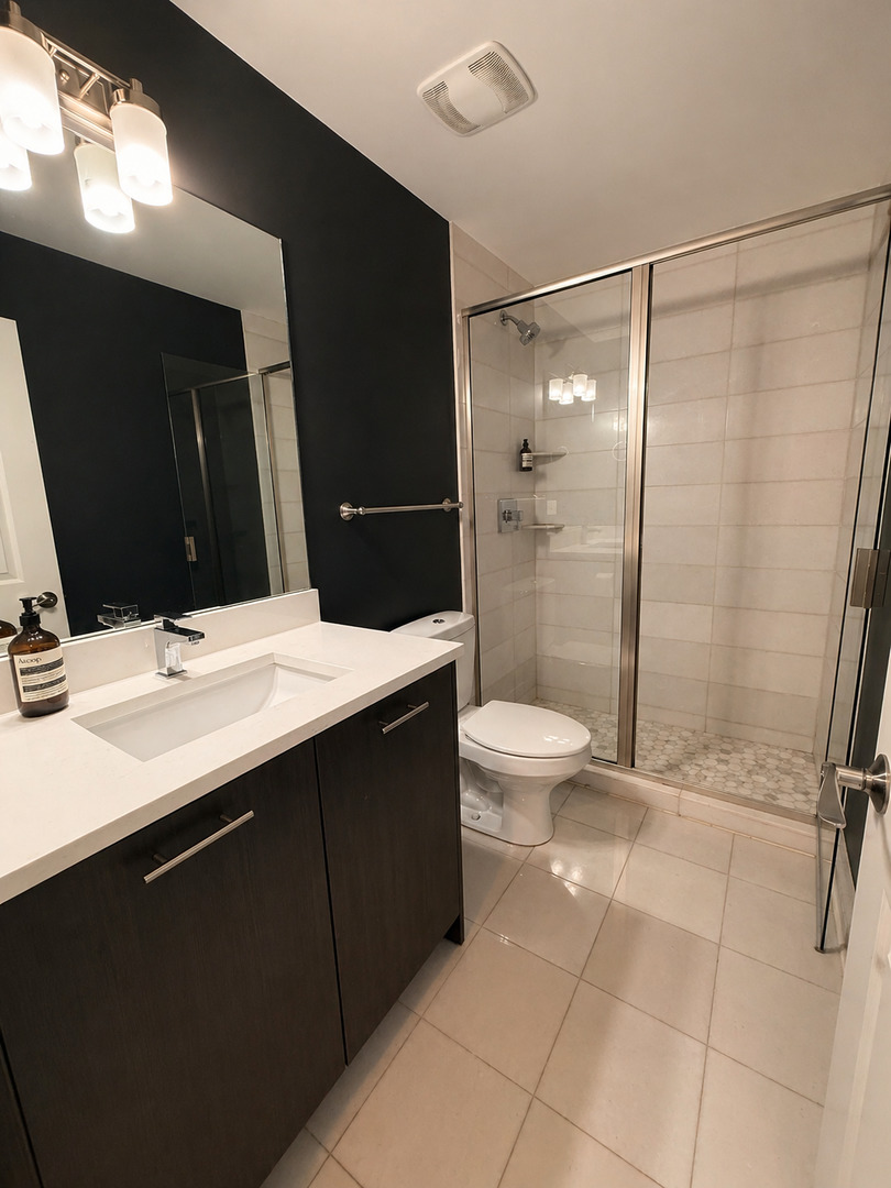 Undisclosed Address Chicago, IL 60608 - Photo 9 of 17 a bathroom with a double vanity sink toilet and shower