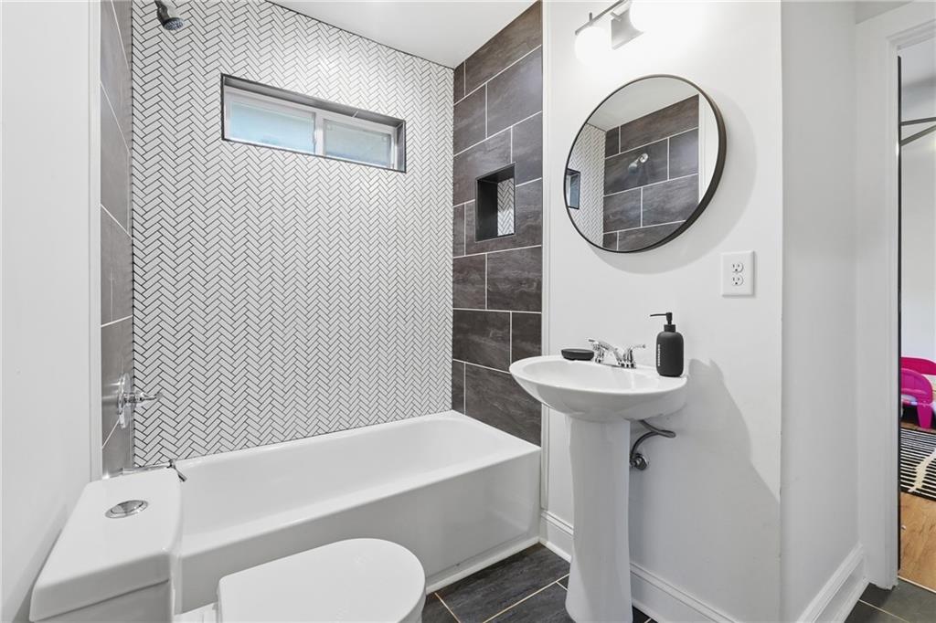 1973 Glendale Drive Decatur, GA 30032 - Photo 22 of 28 a bathroom with a sink a mirror and a bathtub