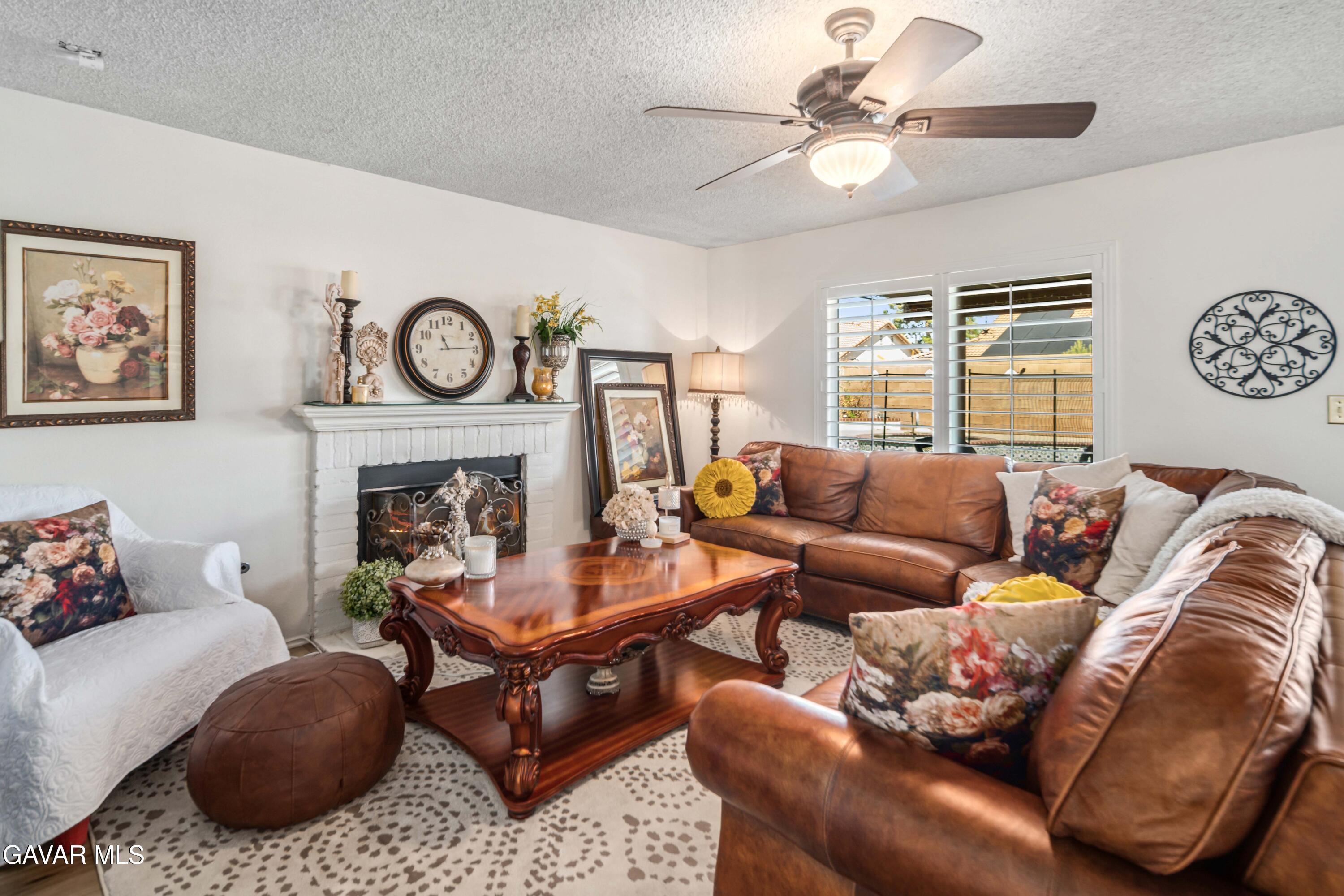 4535 Talento Way Palmdale, CA 93551 - Photo 15 of 43 a living room with furniture a clock on wall and a fireplace