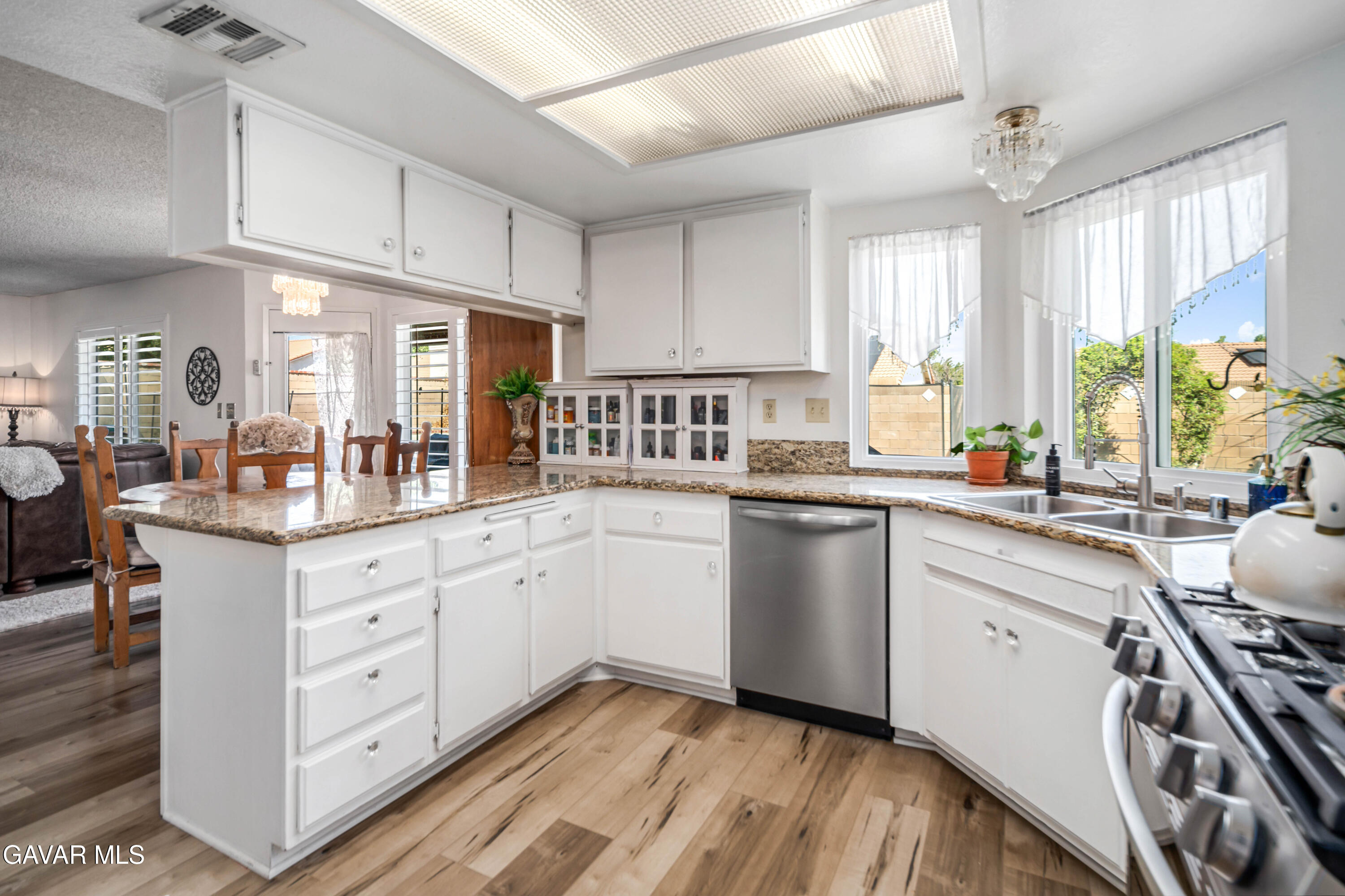 4535 Talento Way Palmdale, CA 93551 - Photo 10 of 43 a kitchen with granite countertop white cabinets white appliances a sink and a large window