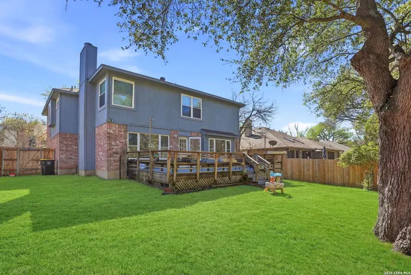 a view of a house with backyard and a tree