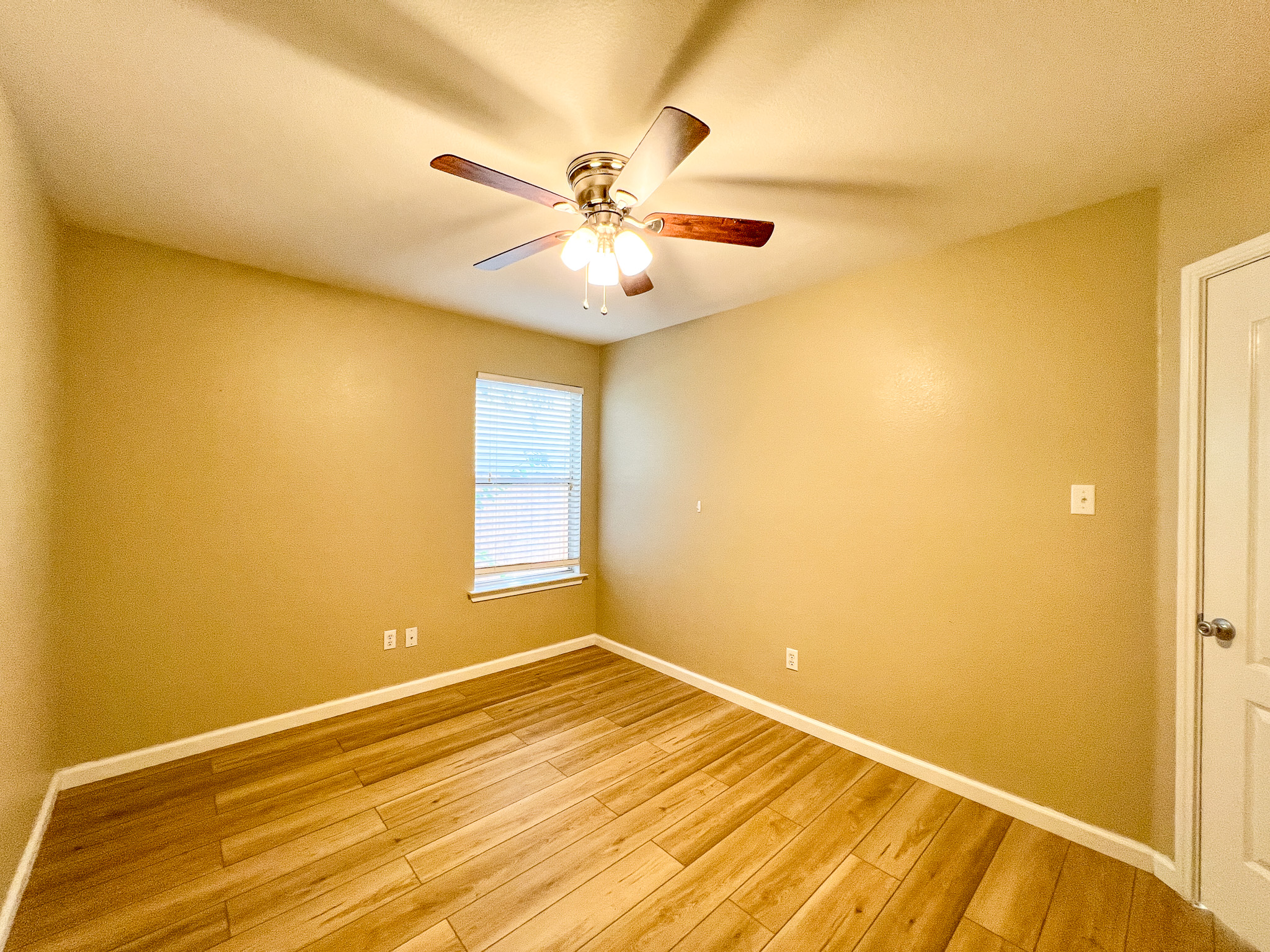 298 Jack Rabbit Lane Buda, TX 78610 - Photo 9 of 24 A quiet bedroom showcases light wood flooring and a refreshing ceiling fan.