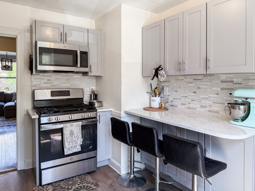 84 Strathmore Road, Unit 4 Boston, MA 02135 - Photo 3 of 14 a kitchen with stainless steel appliances a stove a sink and a microwave