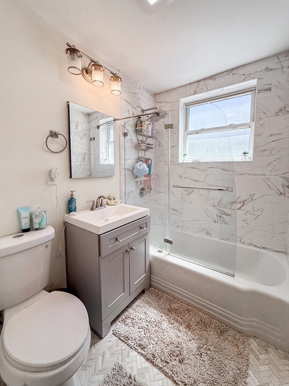 84 Strathmore Road, Unit 4 Boston, MA 02135 - Photo 8 of 14 a bathroom with a granite countertop toilet sink and mirror