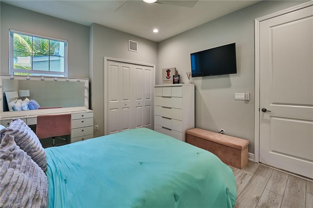 2664 Seychelles Circle, Unit 2402 Naples, FL 34112 - Photo 14 of 30 a bedroom with a bed and a flat screen tv