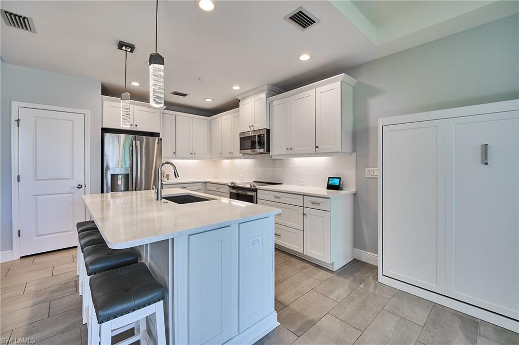 2664 Seychelles Circle, Unit 2402 Naples, FL 34112 - Photo 3 of 30 a kitchen with a sink a counter top space and stainless steel appliances