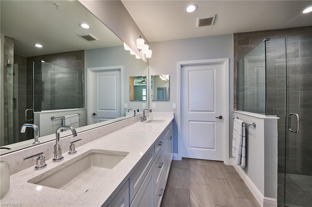 2664 Seychelles Circle, Unit 2402 Naples, FL 34112 - Photo 10 of 30 a bathroom with a double vanity sink a vanity and shower