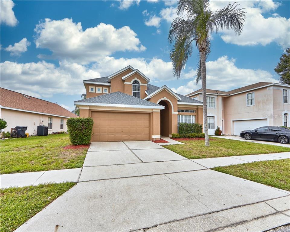 336 Riggs Circle Davenport, FL 33897 - Photo 1 of 1 a front view of a house with a yard and garage