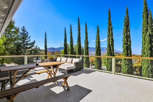 a patio with table and chairs and potted plants