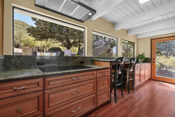 a dining room with wooden floor a chandelier a wooden table and chairs