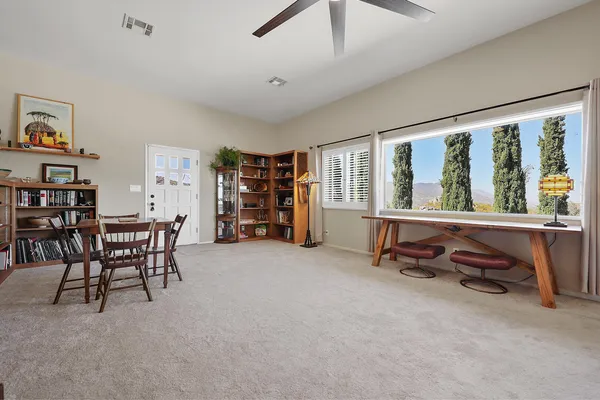 a workspace with furniture window and a ceiling fan