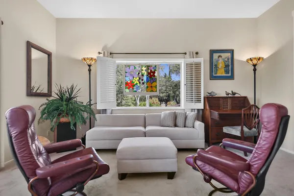 a living room with furniture a fireplace and a large window