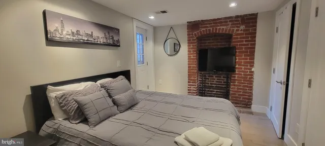 a bedroom with bed and a painting on the wall