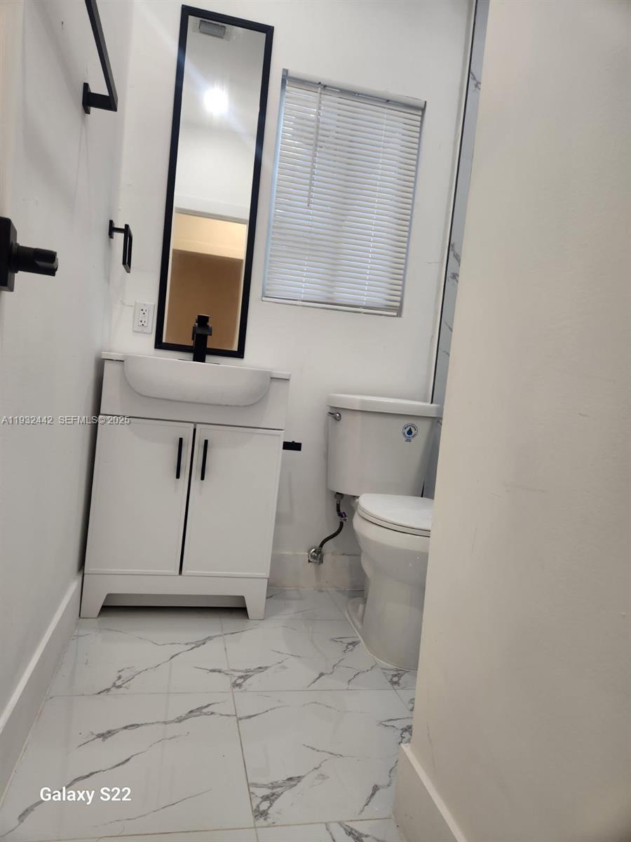 45 Northeast 60th Street Miami, FL 33137 - Photo 5 of 17 a bathroom with a toilet sink and mirror