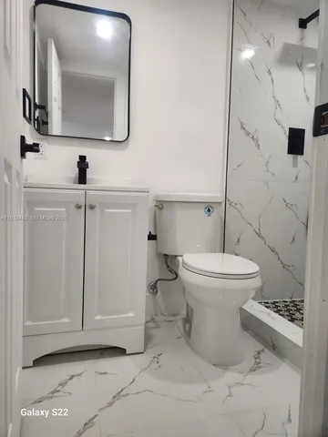 a bathroom with a toilet sink and mirror