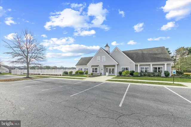 a front view of a house with a garden and trees