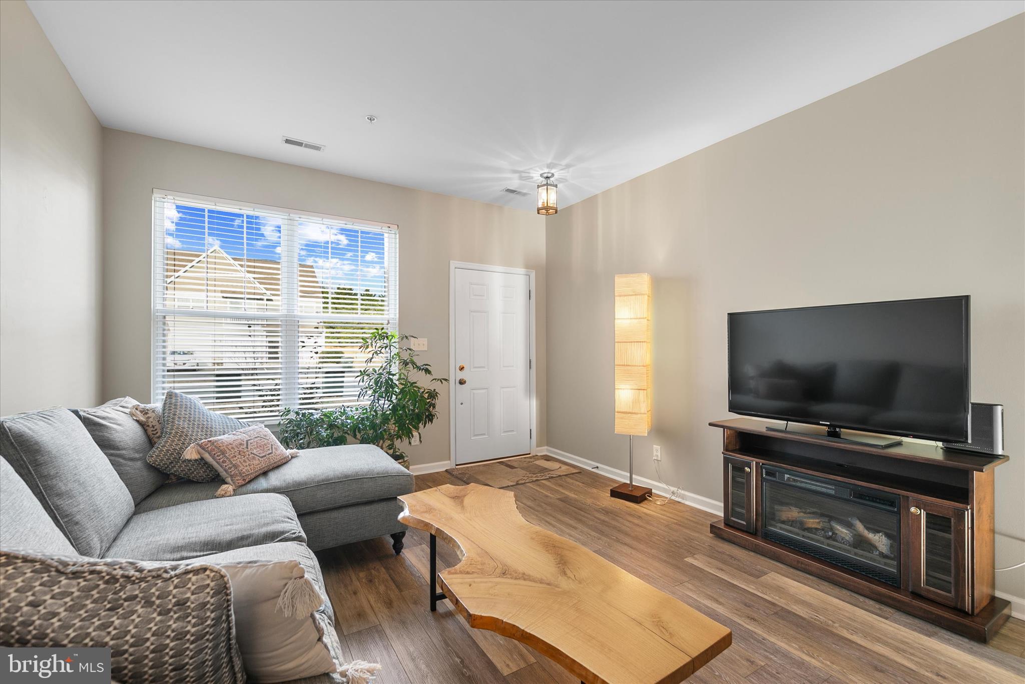 197 Intrepid Lane, Unit 1302 Berlin, MD 21811 - Photo 4 of 20 a living room with furniture and a flat screen tv