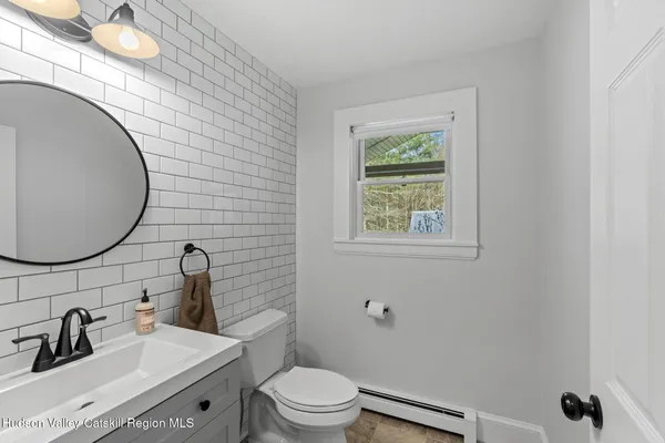 a bathroom with a sink mirror vanity and toilet