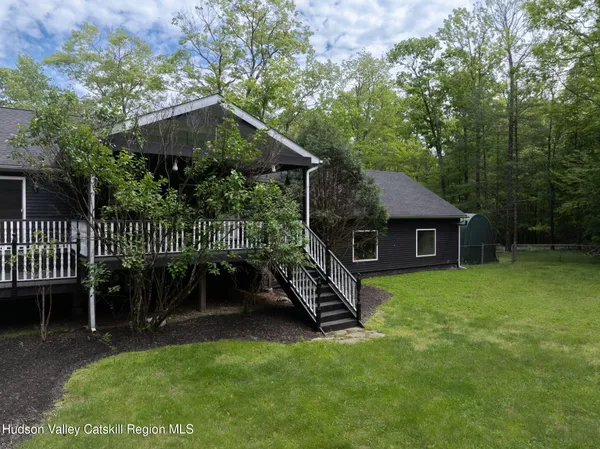 a view of a house with a yard and deck