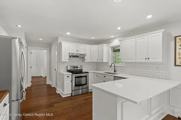 a kitchen with stainless steel appliances granite countertop a sink stove and refrigerator