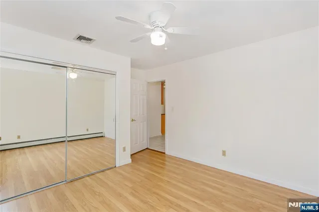 an empty room with a window and ceiling fan
