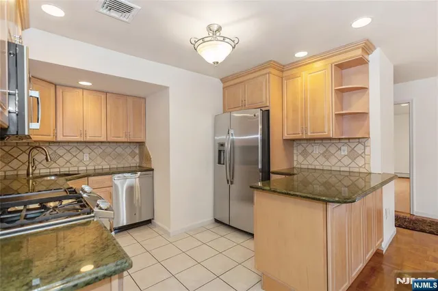 a kitchen with stainless steel appliances granite countertop a refrigerator and a sink