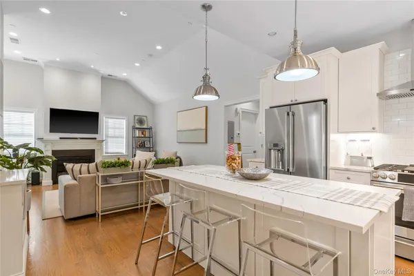 a kitchen with stainless steel appliances kitchen island granite countertop a stove a sink a dining table and chairs