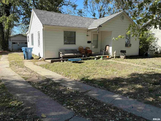 a view of a house with backyard space and a tree