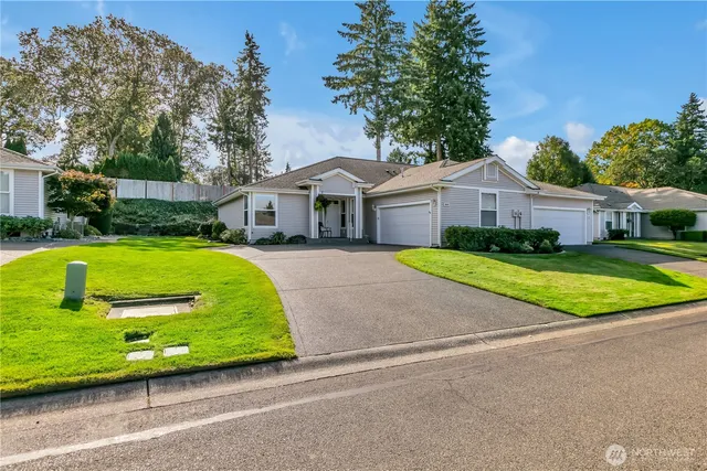 a view of a house with a big yard and large trees