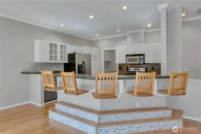 a kitchen with stainless steel appliances granite countertop a refrigerator and a stove top oven