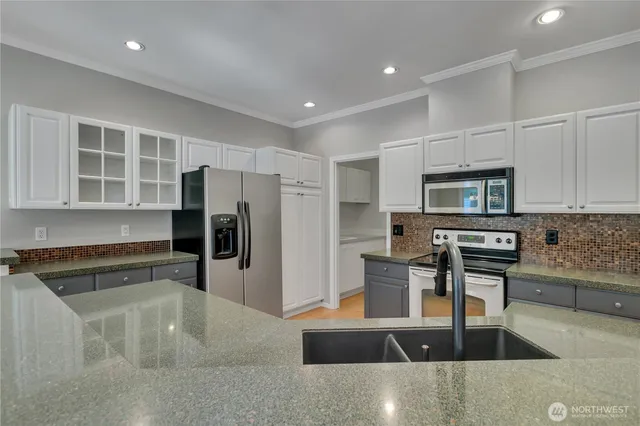 a kitchen with stainless steel appliances granite countertop a sink and a stove top oven with wooden floor