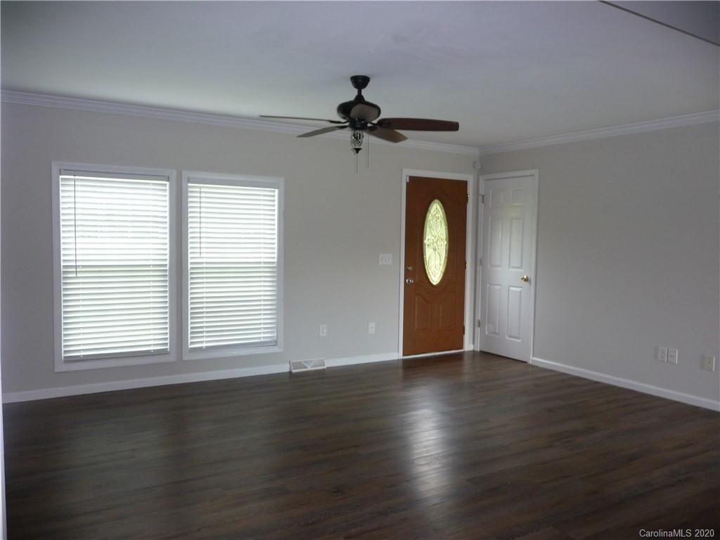 4222 Richardson Road Monroe, NC 28112 - Photo 2 of 21 an empty room with wooden floor fan and windows