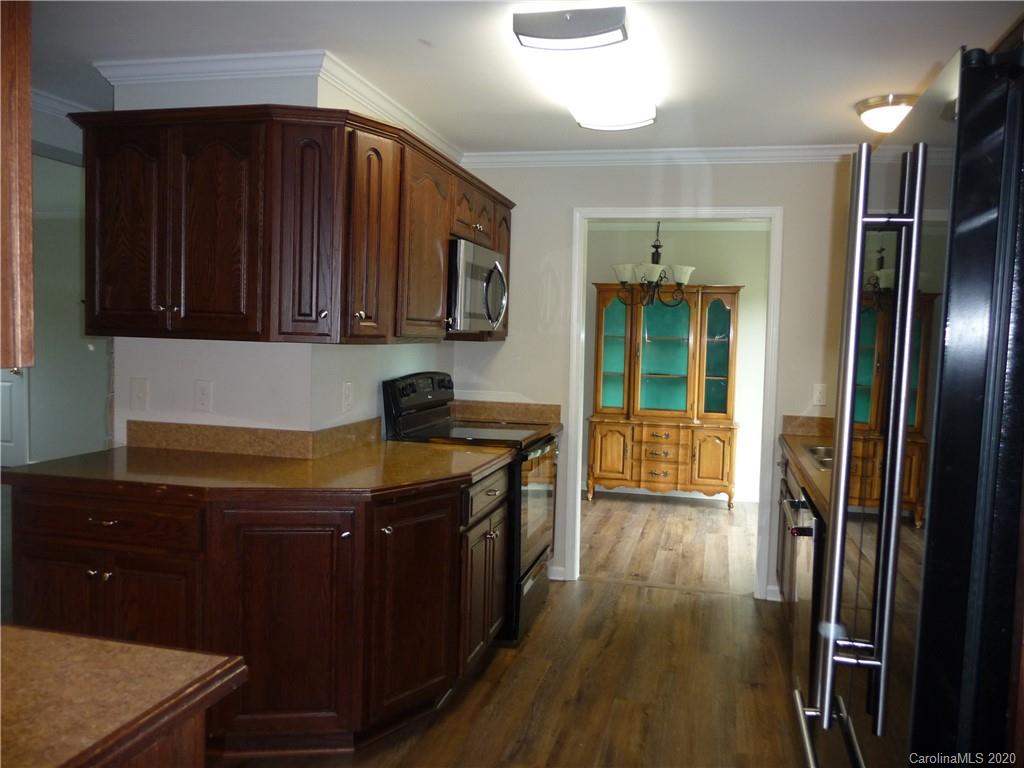 4222 Richardson Road Monroe, NC 28112 - Photo 6 of 21 a kitchen with granite countertop a refrigerator a stove and wooden floor