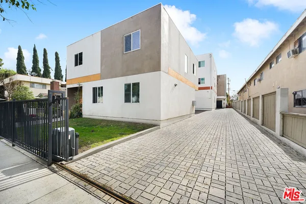 a view of a white house with a yard