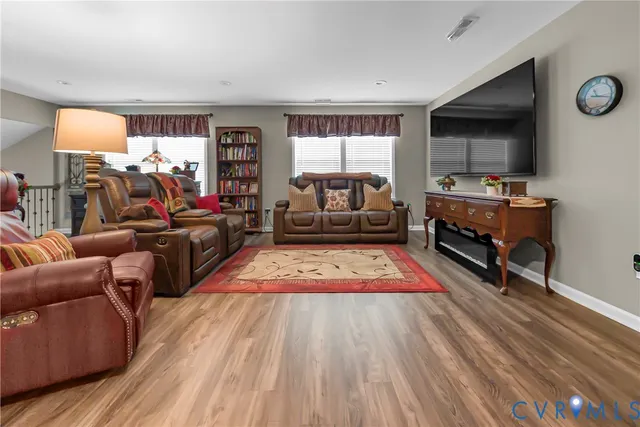 a living room with furniture hard wood floor and a window