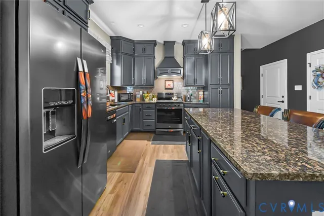 a large kitchen with kitchen island granite countertop a large counter top and stainless steel appliances