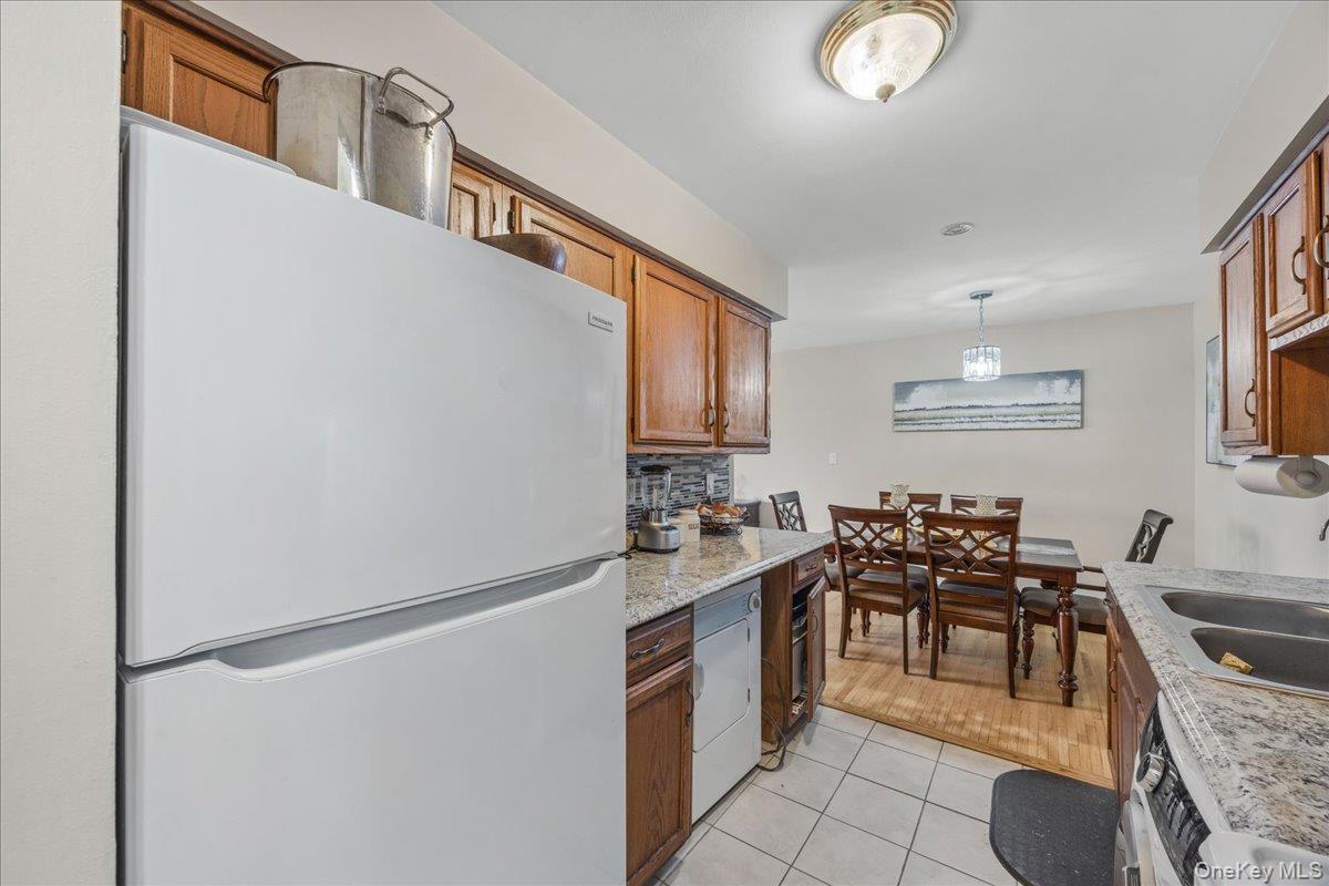 782 Tuckahoe Road, Unit 3C Yonkers, NY 10710 - Photo 10 of 19 a kitchen with stainless steel appliances granite countertop a refrigerator a stove a sink dishwasher and white cabinets with wooden floor