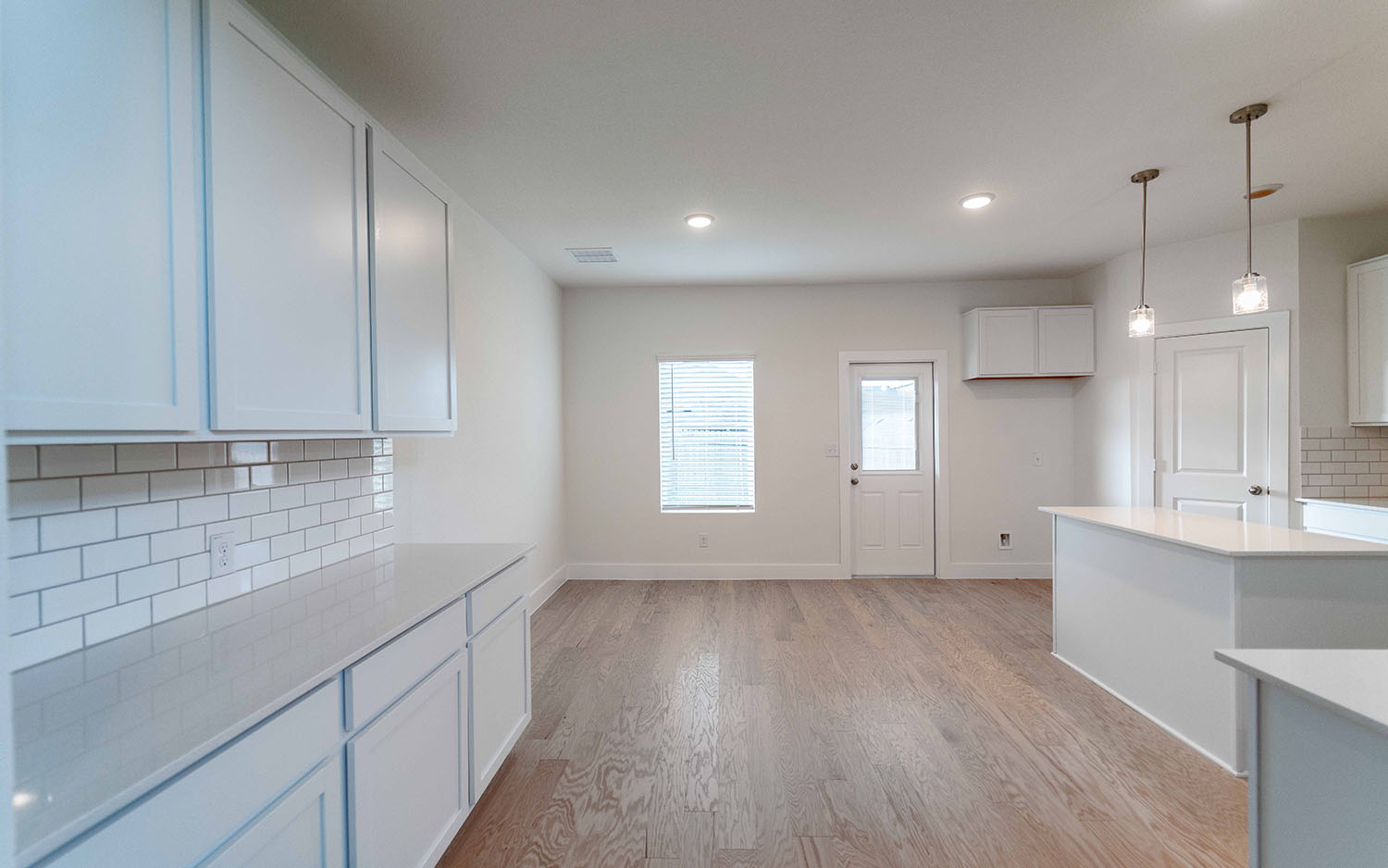 104 Old Silver Drive Jarrell, TX 76537 - Photo 7 of 19 Kitchen with tasteful backsplash, light wood finished floors, pendant lighting, light countertops, and recessed lighting